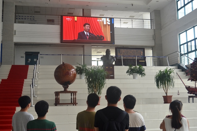 学院学生驻足观看大屏幕播放的庆祝中国人民解放军建军90周年大会 刘伟摄影